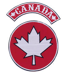 Two embroidered patches: a circular red patch with a white maple leaf outlined in black, and a curved red banner with the white text "CANADA" flanked by white maple leaves.