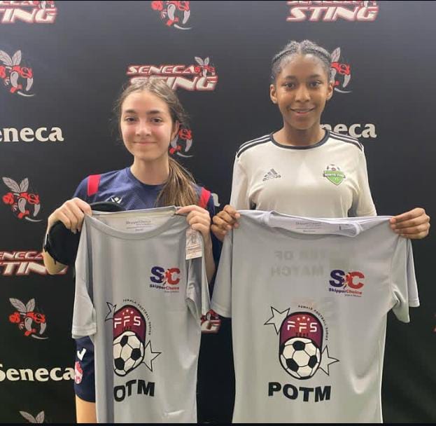 Two female soccer players holding 'Player of the Match' (POTM) shirts at a Seneca Sting event, featuring FFS and SkipperChoice branding