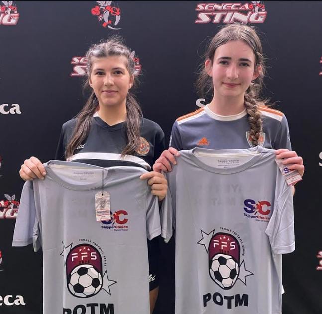 Two female soccer players holding 'Player of the Match' (POTM) shirts at a Seneca Sting event, featuring FFS and SkipperChoice branding